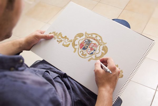 Hombre con cuaderno y bolígrafo en la mano derecha pintando el logo de una empresa de eventos