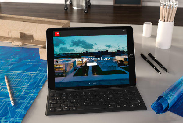 Fotografía de ordenador enseñando el diseño de una página web de la Universidad de málaga, este ordenador esta sobre una mesa de una oficina