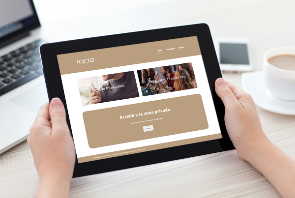 Manos sujetando IPad que enseña sitio web de la empresa Iqos