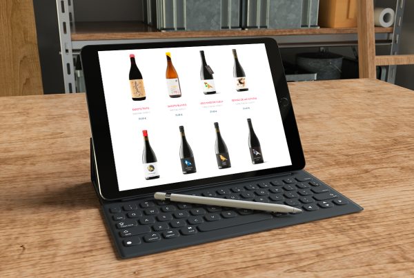 IPad enseñando una web de venta de vino online, que está sobre escritorio de madera